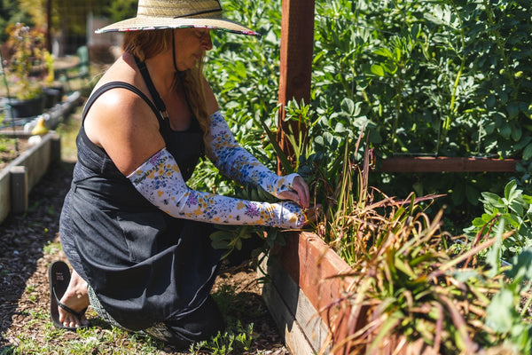 Woman using Save the Bees Sleeves to prune her garden.