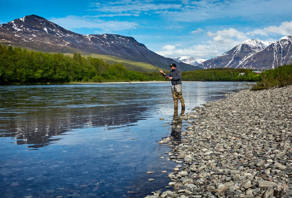 A man fishing on a river. 