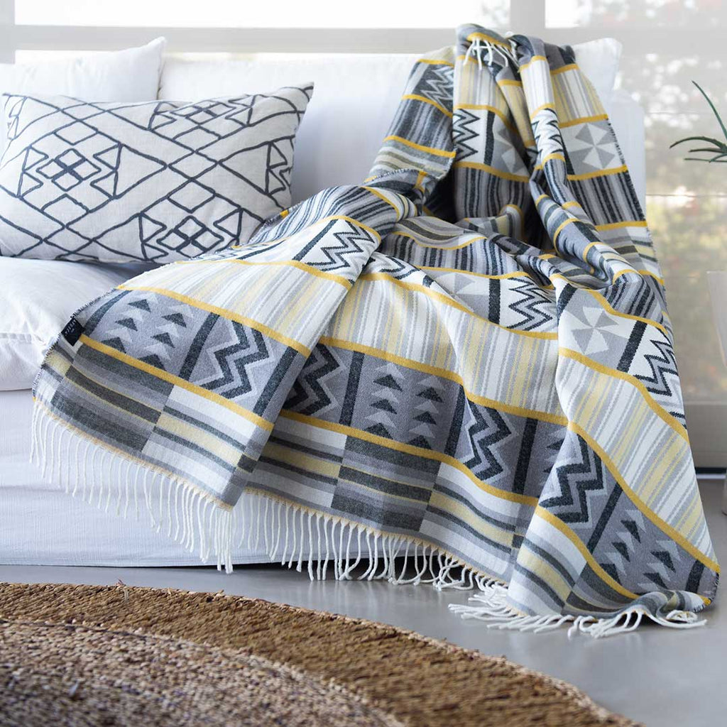Ghana kente yellow and grey throw on a white couch 