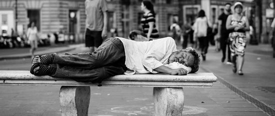 Blankets for the homeless man sleeping on a bench in street park