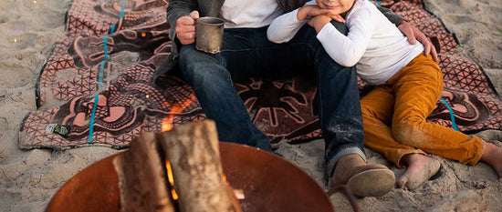 basotho wool camping blanket on beach with son and father in front of camping fire