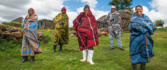 HOW TO WEAR A BASOTHO BLANKET - Basotho blanket women standing in green grass overlooking lesotho