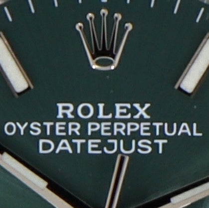 Rolex crown on green dial