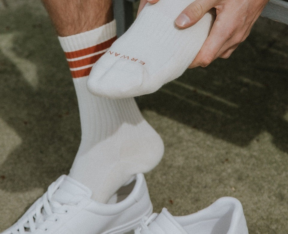 man with white socks with plantar fasciitis foot pain 