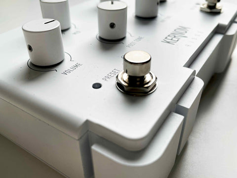 Photo of the Kernom RIDGE, a new and modern overdrive pedal. The photo makes a focus on the PRESET footswitch, which allows you to save a setting and recall it at will.