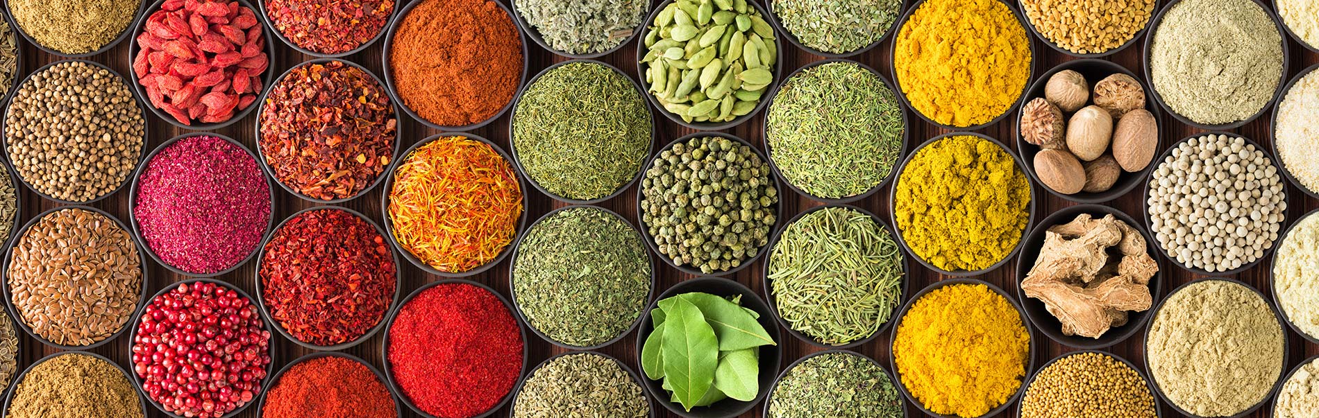 circular containers holding an array of many spices seen from overhead