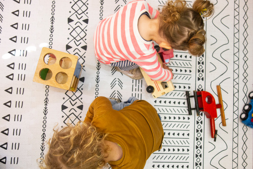 Twins on baby play mat