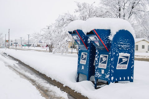 Two USPS mailboxes covered in snow