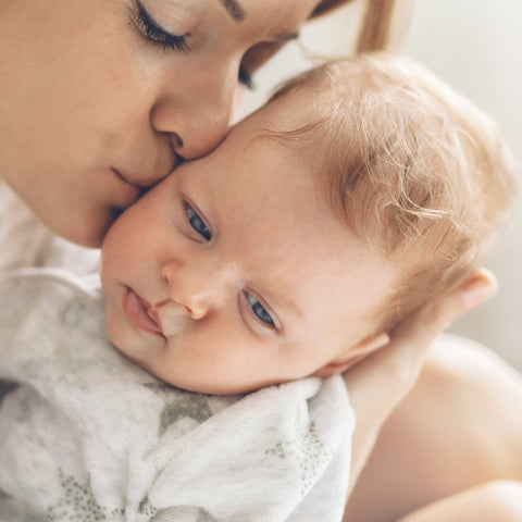 Mother kissing her baby on the cheek