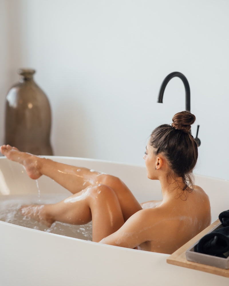 A woman with her hair caught in a bathtub.