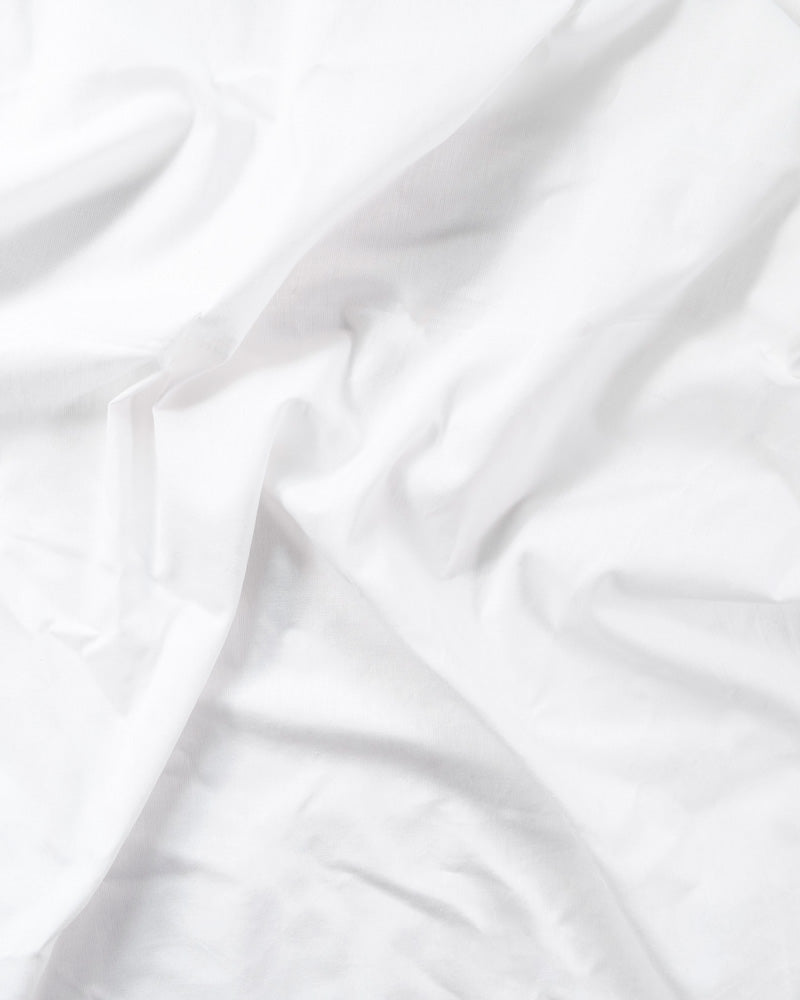 top view of a slightly wrinkled white cotton percale sheet