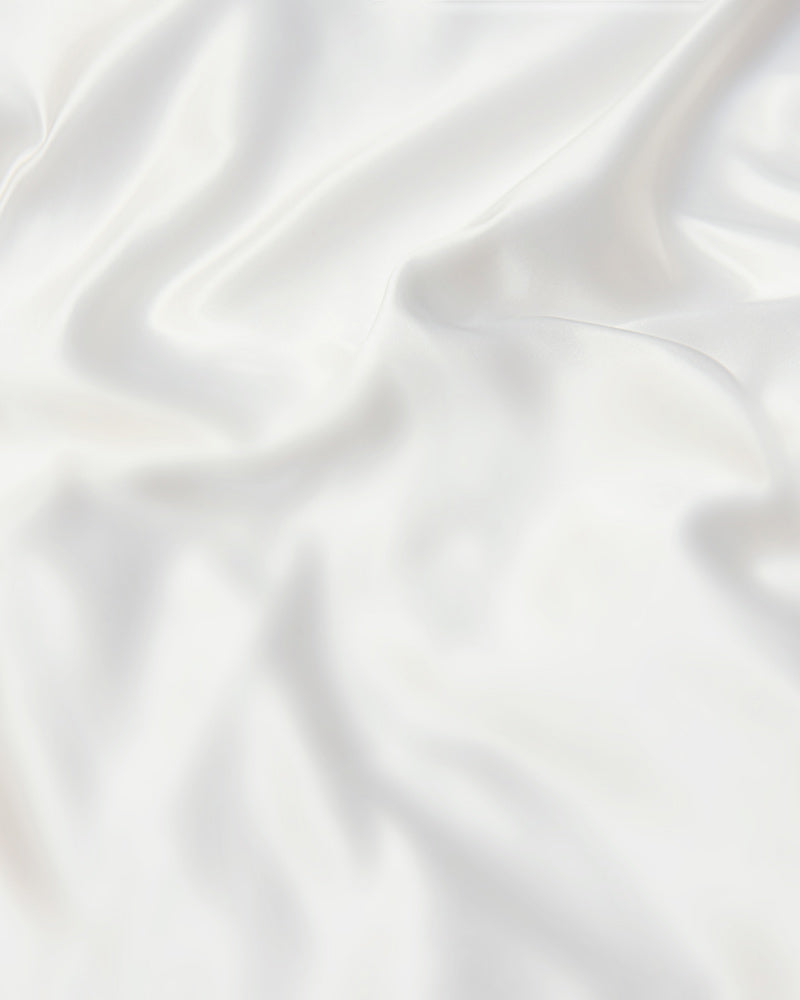 top view of a smooth and glossy ivory mulberry silk sheet
