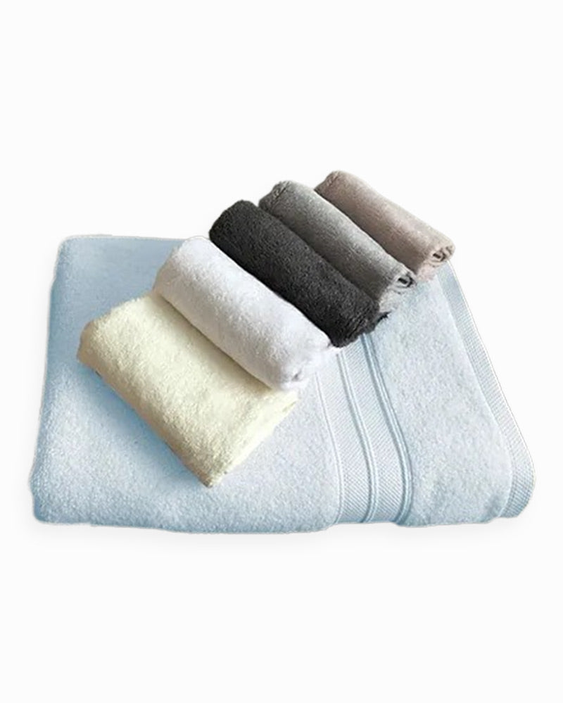 An ivory bath sheet under five wrapped washcloths