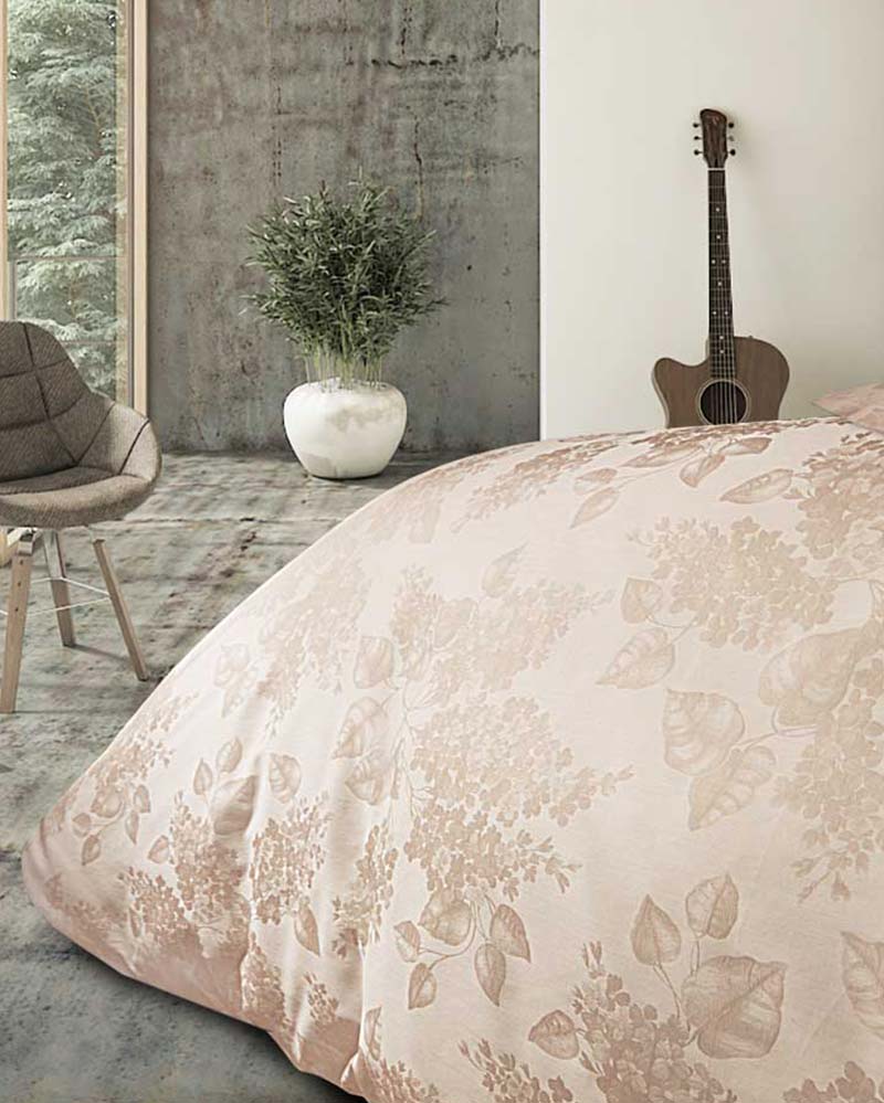 Forest-view room with a chair, a plant and a luxurious duvet with a brow-pinkish floral pattern.