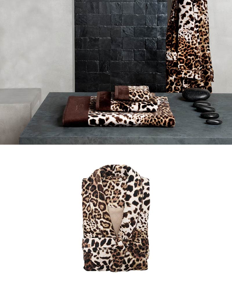 Luxurious leopard print bathrobe hanging at the wall of a luxury bathroom next to Spa hot stones