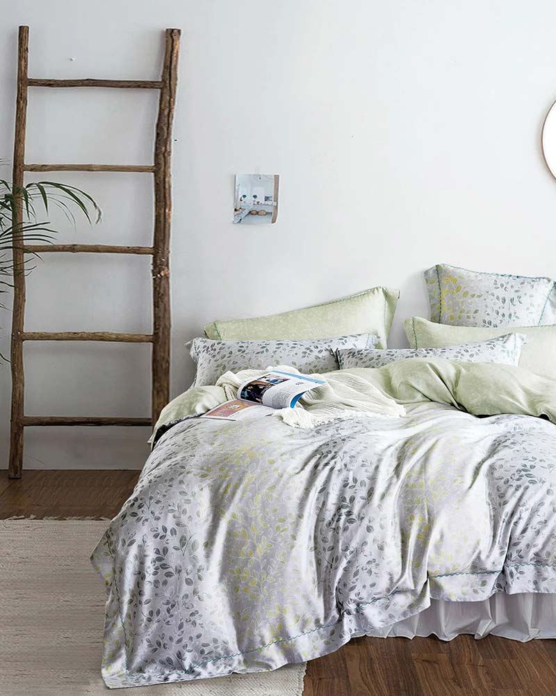 Green and grey Micromodal bedding from St. Pierre next to a wooden ladder and a plant.