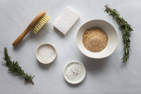 Sea salt, crushed oats, sugar, a brush, an exfoliating stone and some rosemary, all of which you can use for exfoliation and self massage