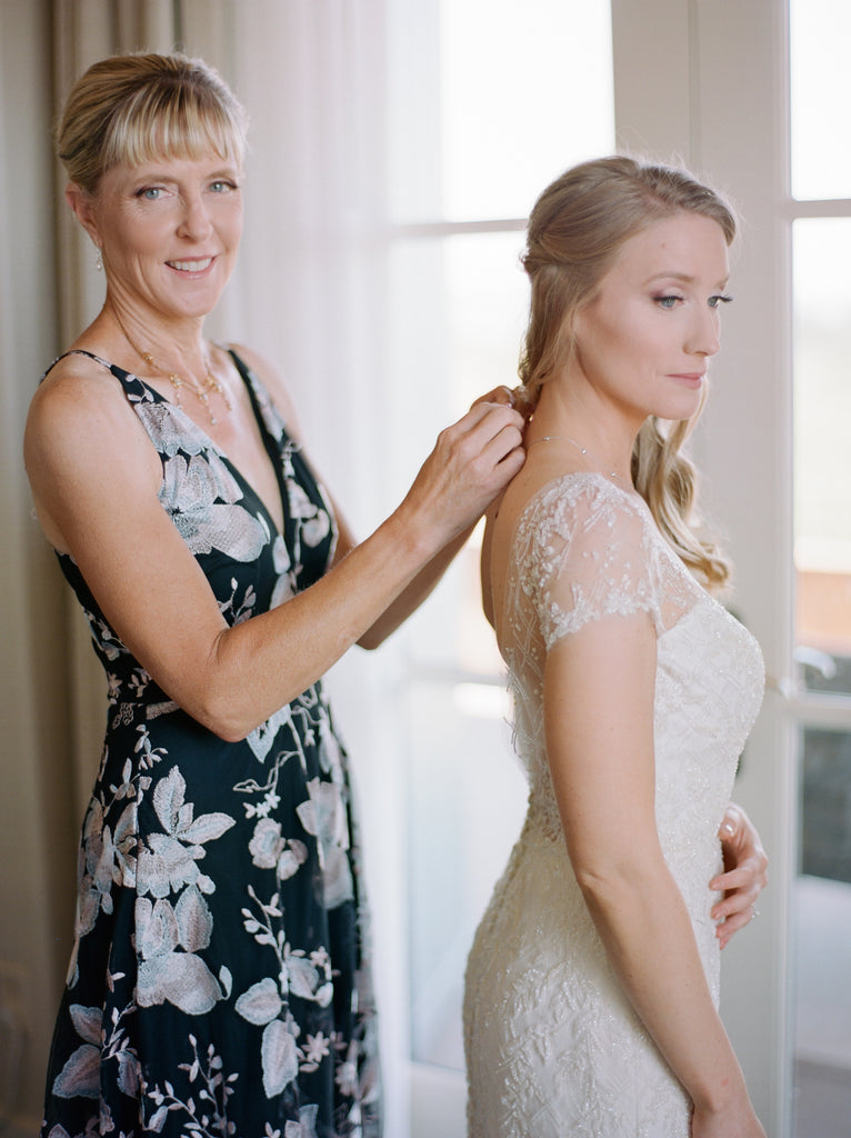 The Rose Gown is a romantic wedding dress with a scooped neckline, illusion short sleeves, and deep scooped illusion back, on a fitted trumpet silhouette. #weddingdress #capsleevedress #weddingdresses #bridal #bridalgown