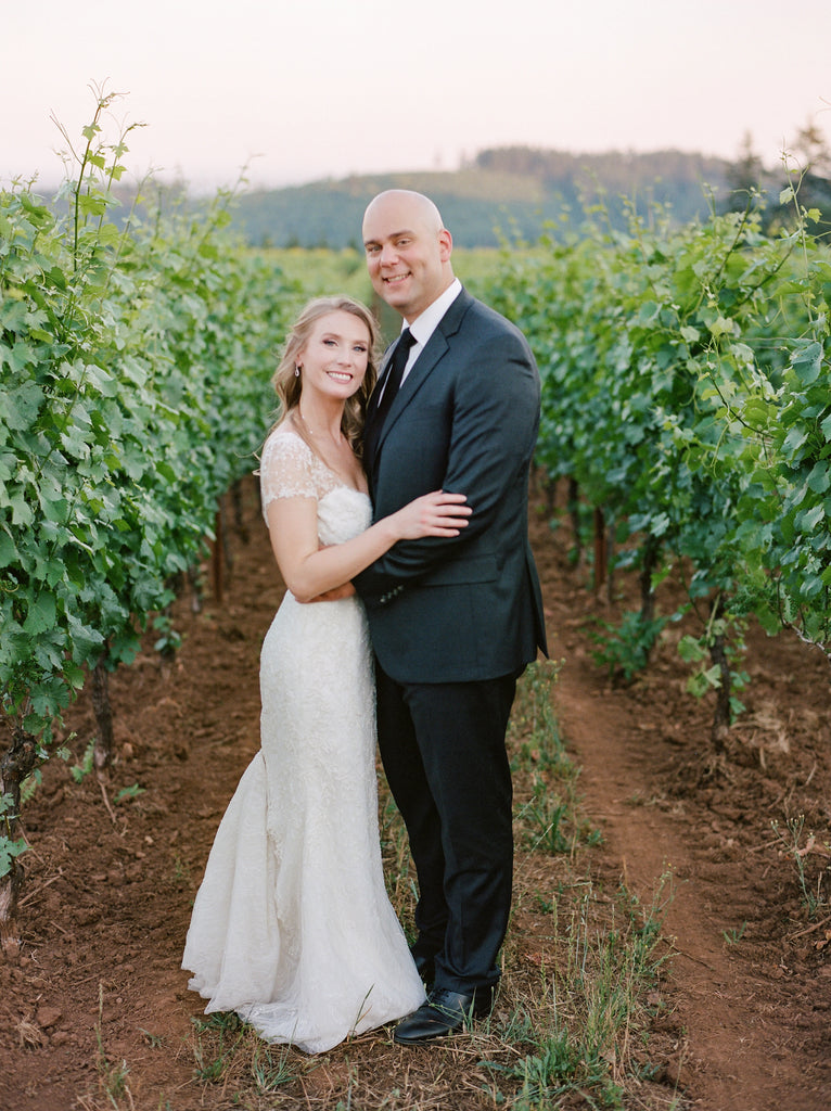 The Rose Gown is a romantic wedding dress with a scooped neckline, illusion short sleeves, and deep scooped illusion back, on a fitted trumpet silhouette. #weddingdress #capsleevedress #weddingdresses #bridal #bridalgown