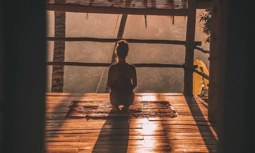 woman meditating to reduce stress, which can help manage symptoms of seborrheic dermatitis