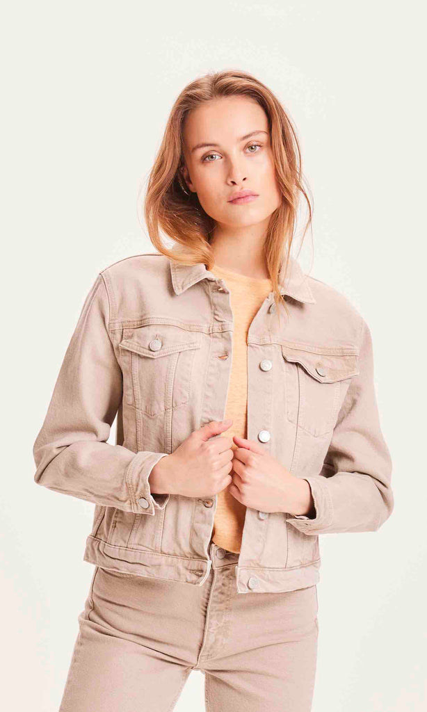 Une femme de face porte une veste en jean écru de la marque Knowledge Cotton Apparel.