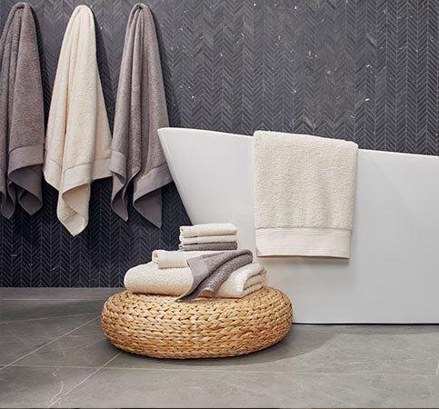 Towel Collection main, bathrrom with towel set on stand, bath tub with bath towel, sink with towels sets underneath