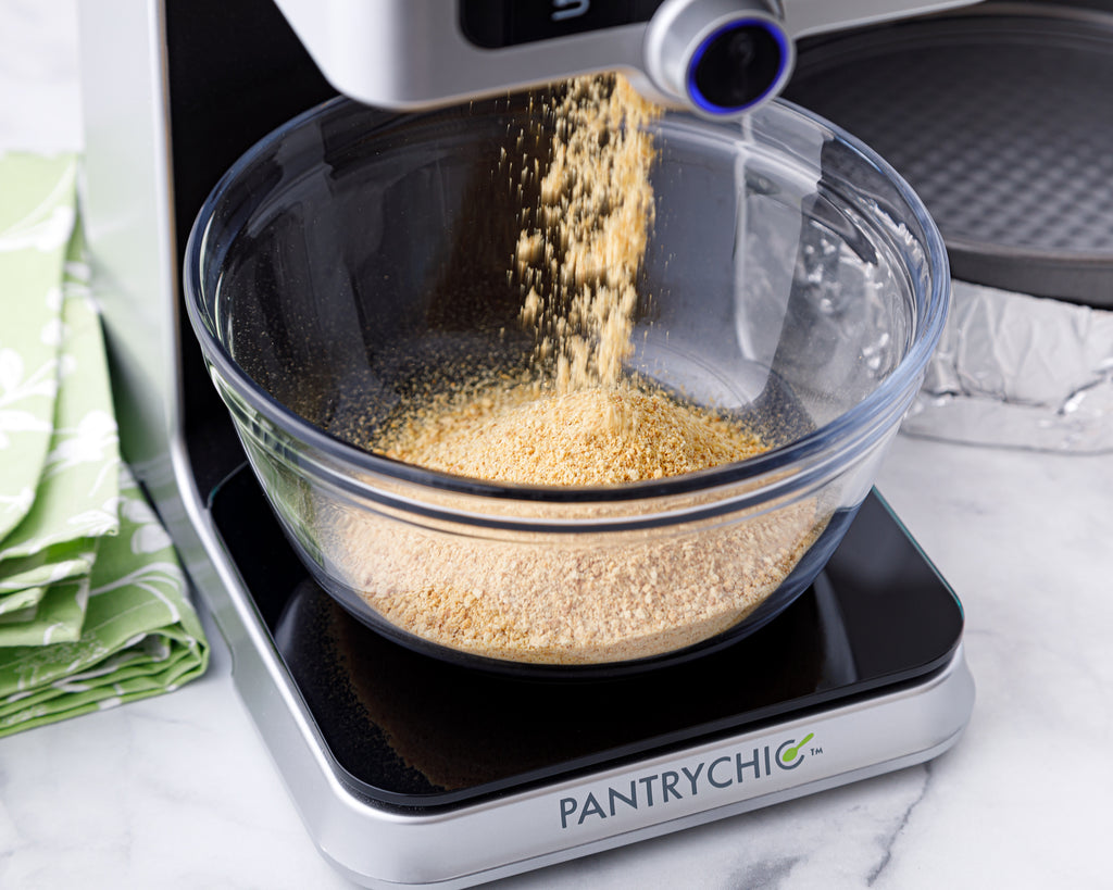 Dispensing graham cracker crumbs into a mixing bowl