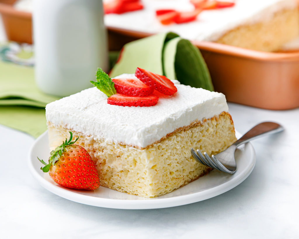 A slice of homemade Tres Leches Cake topped with strawberries