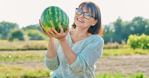 Smiling woman with ripe watermelon. 