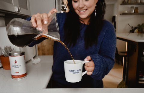 Pouring coffee from a Chemex into a compass mug