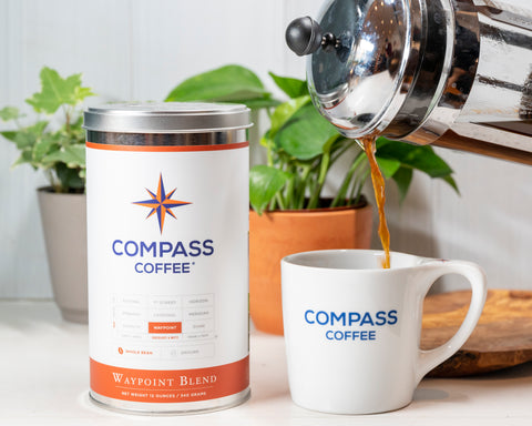 French Press of Cardinal pouring into a Compass mug