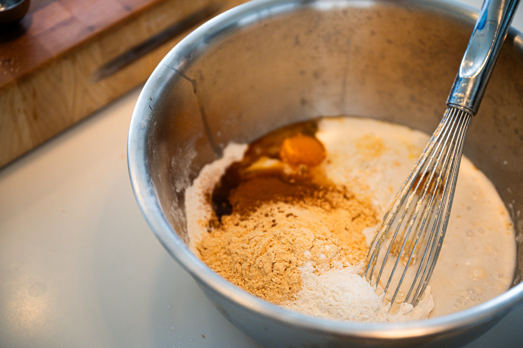 Freshly whisked blend of waffle ingredients in a stainless steel mixing bowl, ready to create a delightful waffle