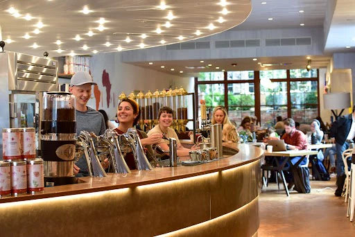 A group of baristas having fun in a Compass Coffee cafe.
