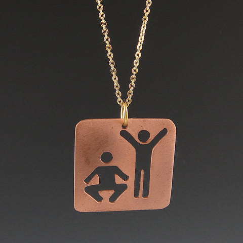 Copper pendant featuring the universal human figures exercising.