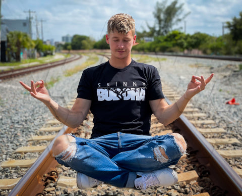 Hip hop artist Smac meditating in skinnybuddha clothing.