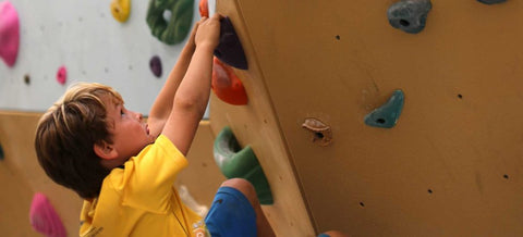 kid climbs a custom climbing wall