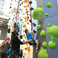 Jason Momoa, star of Aquaman, helps a boy climb the Eldorado Climbing Walls wall at the Variety Boys and Girls Club in Los Angeles.