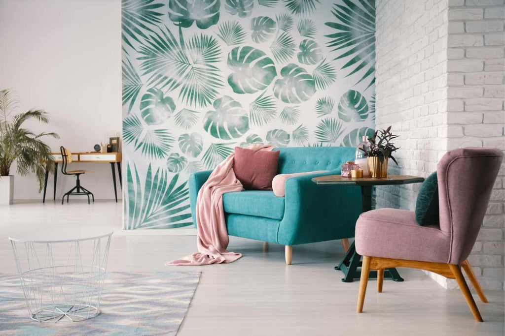 Living room with a white brick wall, light blue couch, and wall with green arboreal wallpaper