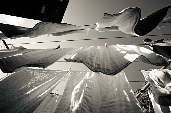 washed clean white cotton towels hanging outside to dry on sun. organic handmade yoga towels best for yoga practice