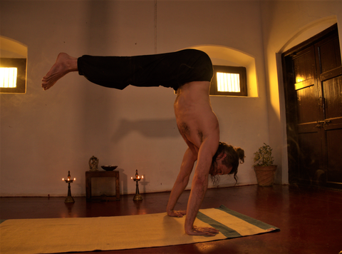 Man practicing handstand on cotton yoga mat