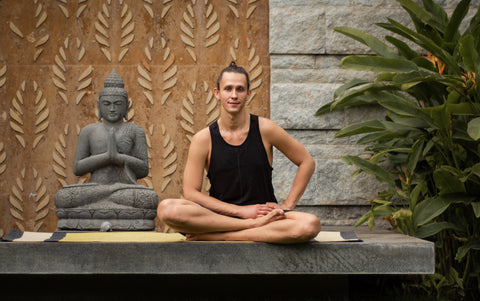 yogi after meditation in the garden on cotton yoga rug