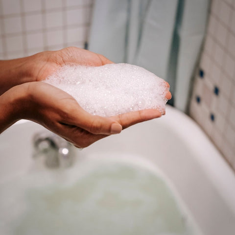 Soap in the woman hands in the bathroom. Ready to wash the cotton yoga rug.