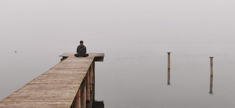 guy meditate on peaceful quiet spot on the lake on cotton yoga rug