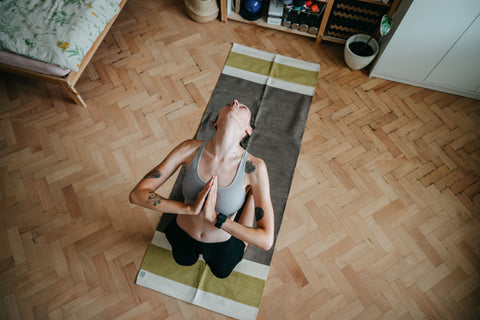 yogini practicing back bending position on natural yoga mat