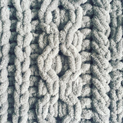 A close up of knitting detail in grey chenille yarn showing a chain link cable.