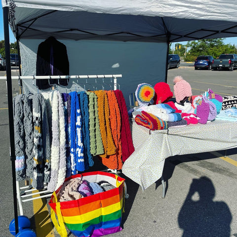 Knitted items arranged for a craft market.