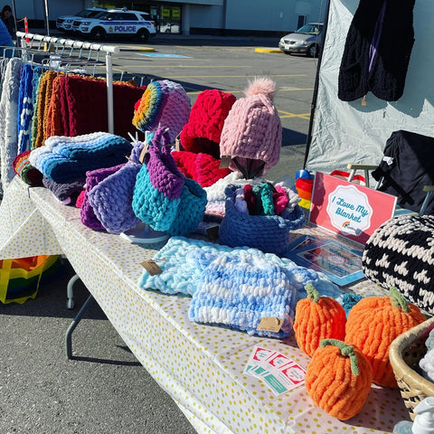 Knitted items laid on a table at a craft show
