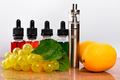 Fruits, Vape Device and E-Liquid Bottles on a Table 