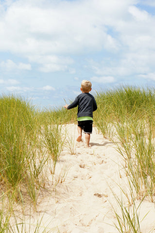 little kid running in the sand