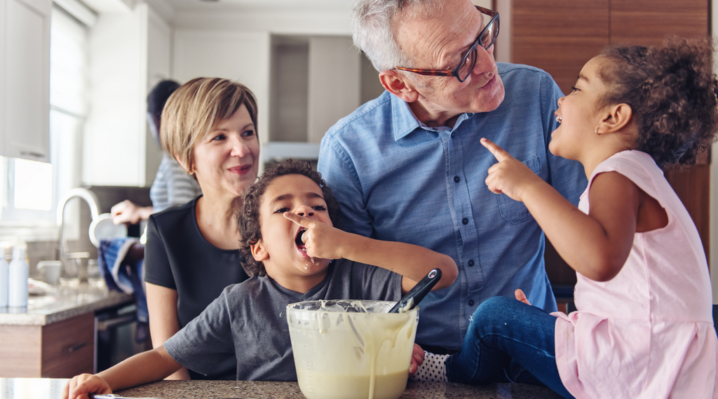 kids tasting and cooking with grandparents in the kitchen